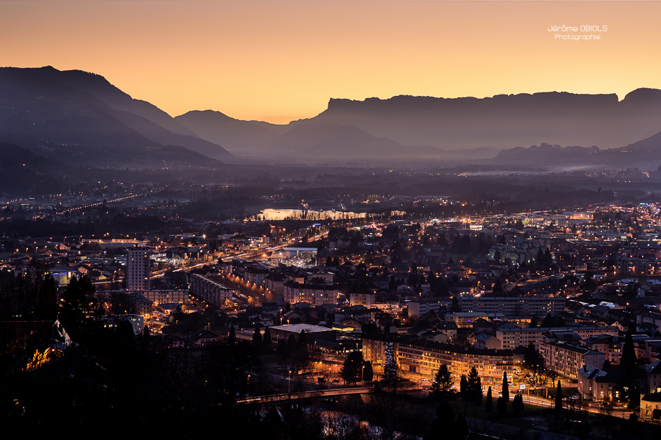 La ville d'Albertville et la combe de Savoie au crépuscule, avec les sommets de Chartreuse et la Dent de Crolles en arriere-plan.