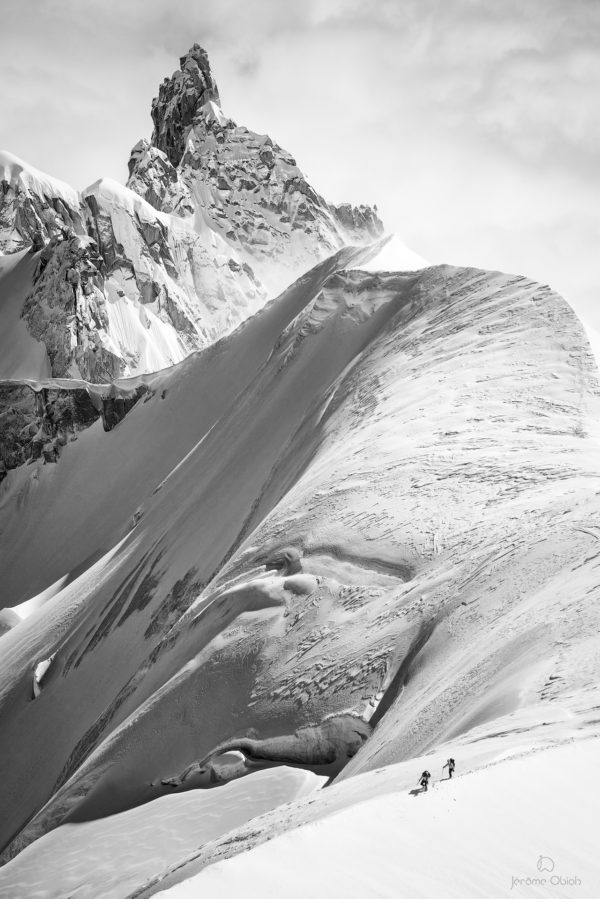 Cordée d'alpinistes sur une arête de neige devant la Dent du Requin.