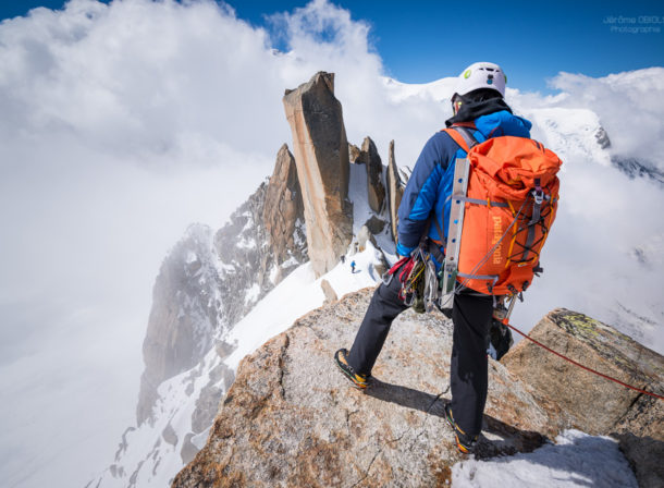 Alpiniste avec un sac a dos Patagonia sur l'Arete des Cosmiques