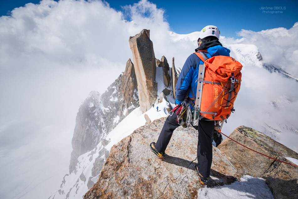 Alpiniste avec un sac a dos Patagonia sur l'Arete des Cosmiques